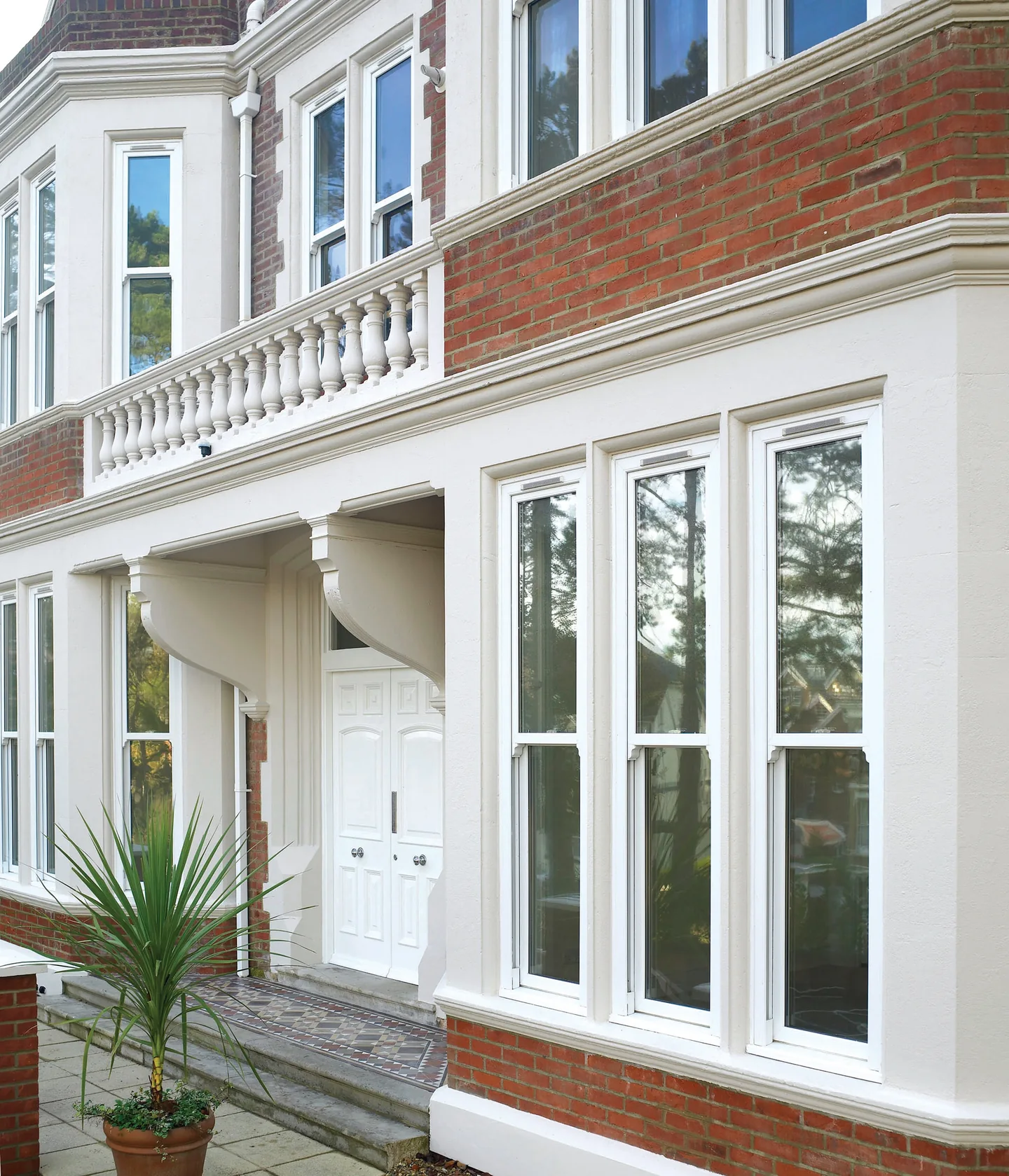 White vertical sliding windows on a traditional home